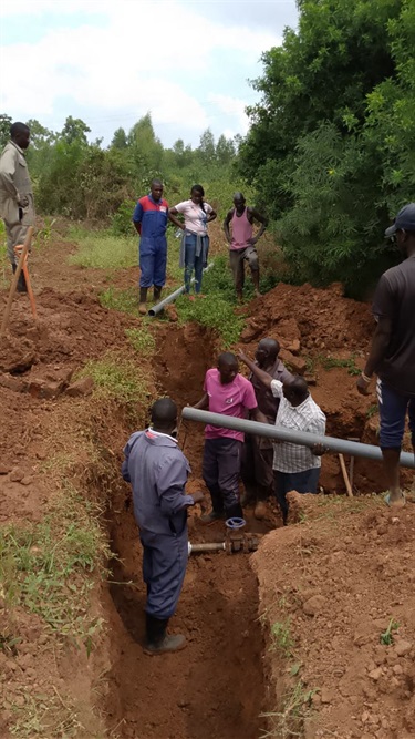 Laying the connections form the water pipe to the community water point.