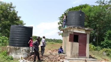 Connecting the water pipe to the Gona Obambo community water point.