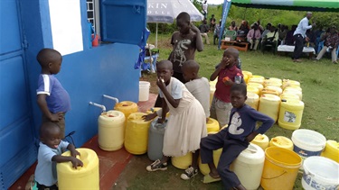 Youngsters fill up water drums.