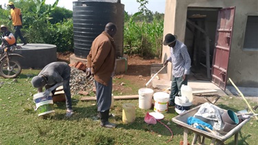 Preparing to paint the community water point ahead of the official opening.