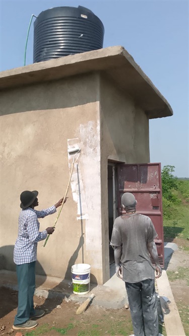 Painting the community water point ahead of the official opening.