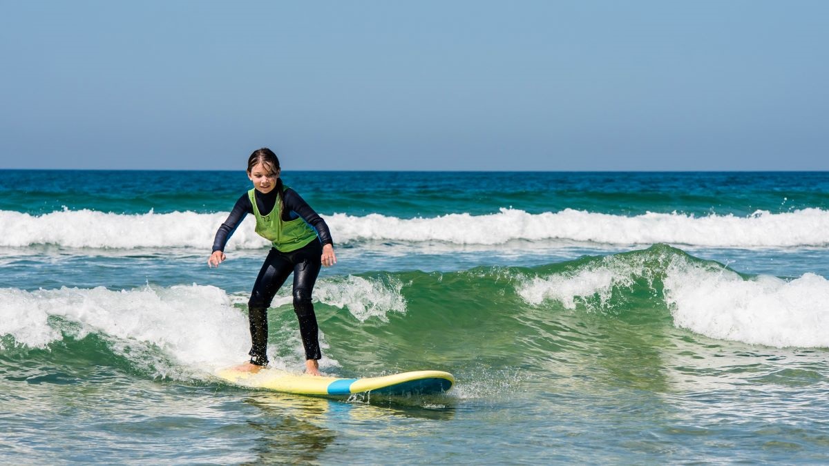 Smiling girl taking surf lesson