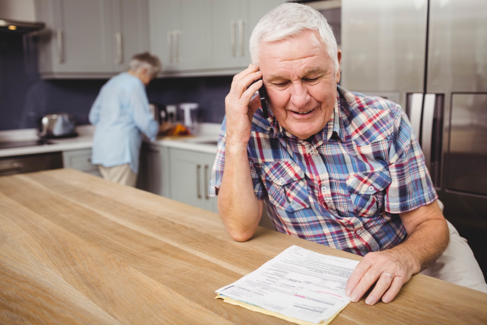 Older man on phone paying bills